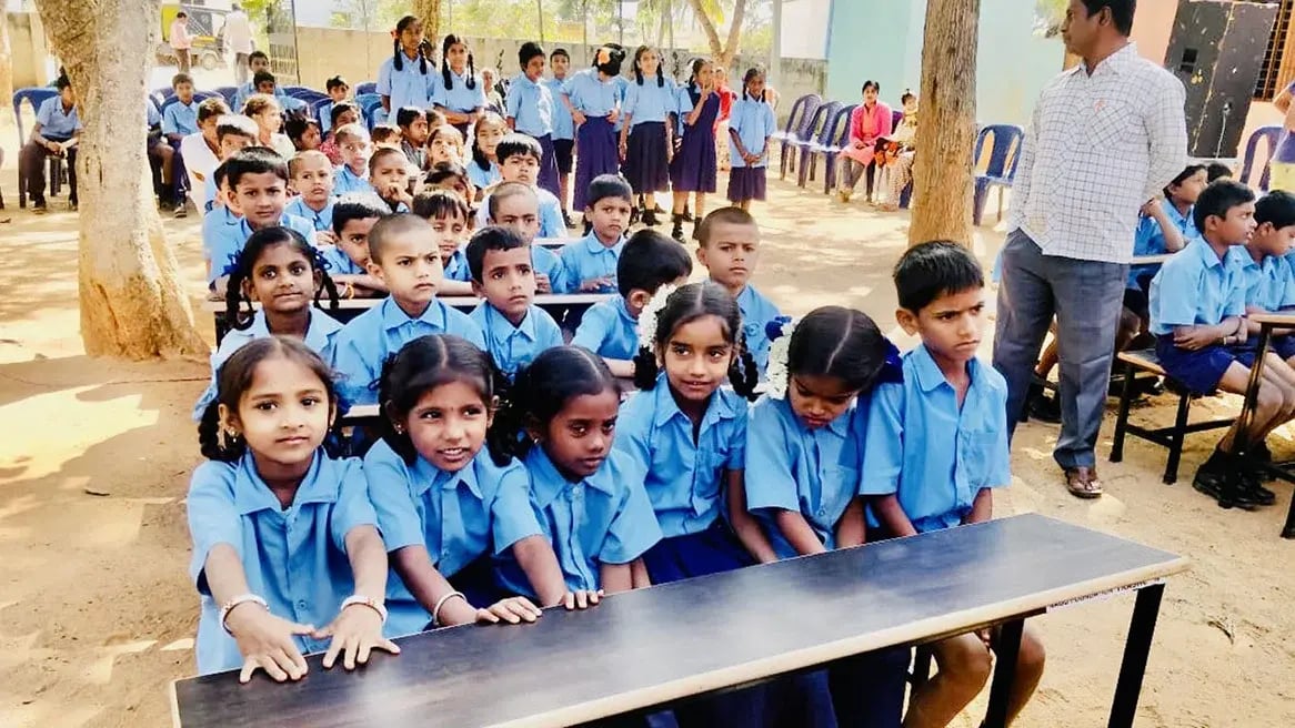 Schoolkinderen in Karnataka bij een schoolbank van gerecycled afval